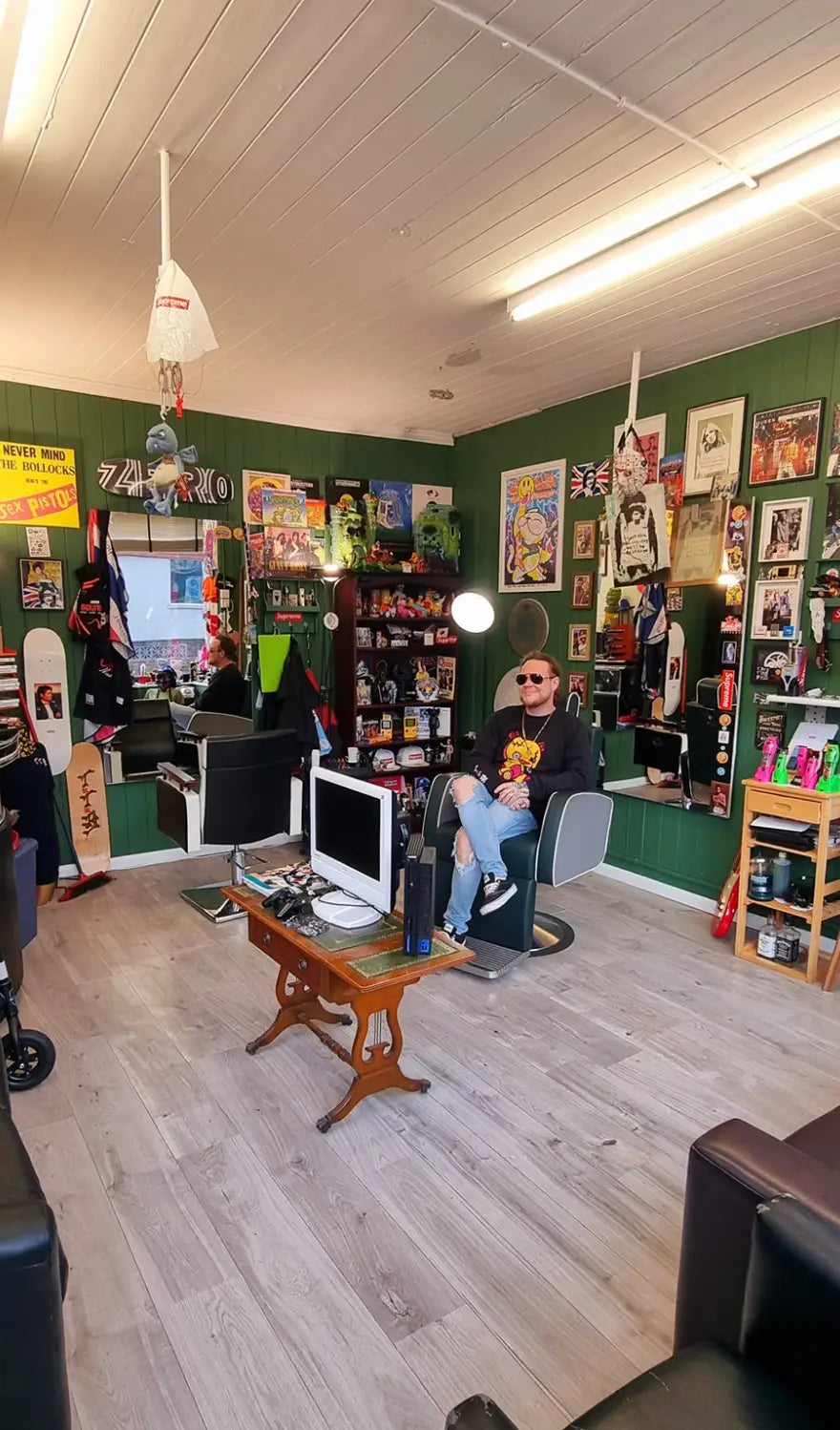 A look inside Paul's Barber Shop, the home of To The Bone, showcasing a unique interior decorated with memorabilia, custom artwork, and To The Bone streetwear, creating a fusion of barbering and fashion culture.